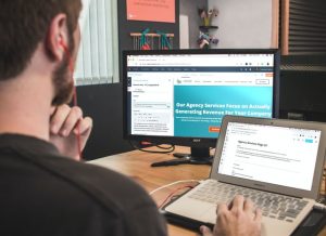 man typing a blog on a website